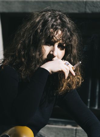 Young woman smoking cigarette in the street