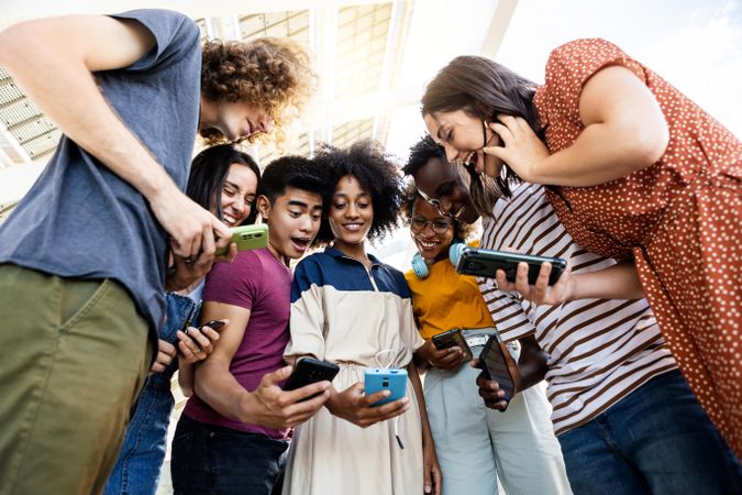 Group of multiracial people using cellphone outdoors