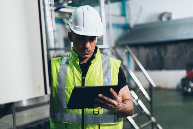 Engineer foreman using digital tablet to repair machine in industrial factory