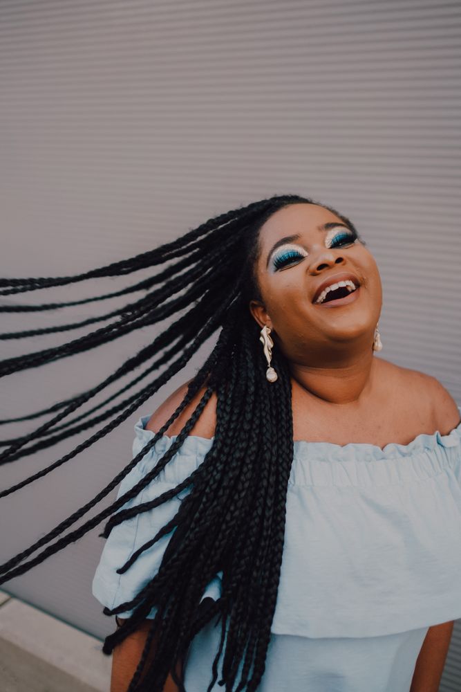 Happy trendy Black woman with flying hair