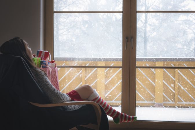 Woman in armchair in front of a snowy window