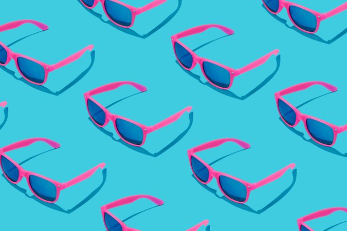 Pattern of pink sunglasses on blue background