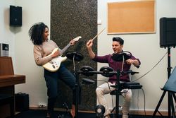 Man playing guitar and woman playing drums