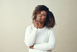 Portrait of contemplative Black woman resting her chin on her hand