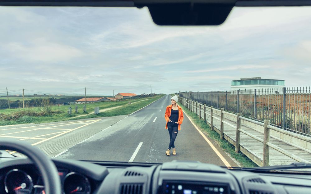 Looking out of van window at women standing on road