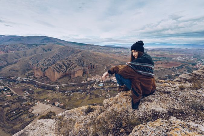 Cheerful woman resting on mountain top