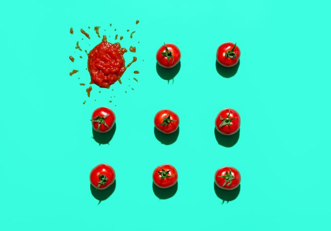 Fresh tomatoes and ketchup isolated on green background