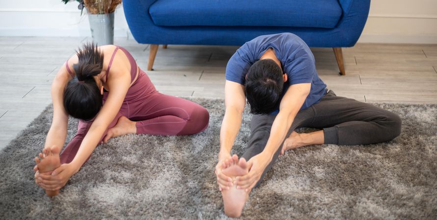 Man an woman stretching in living room