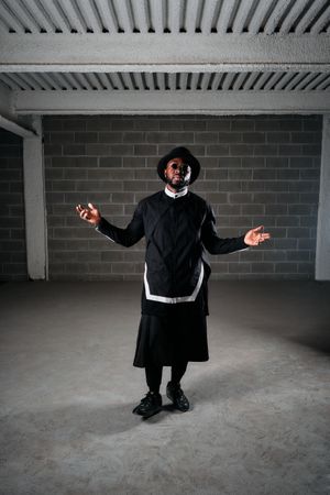 Man wearing dark clothes standing in studio