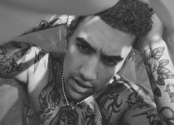 B&W shot of tattooed male under sheet