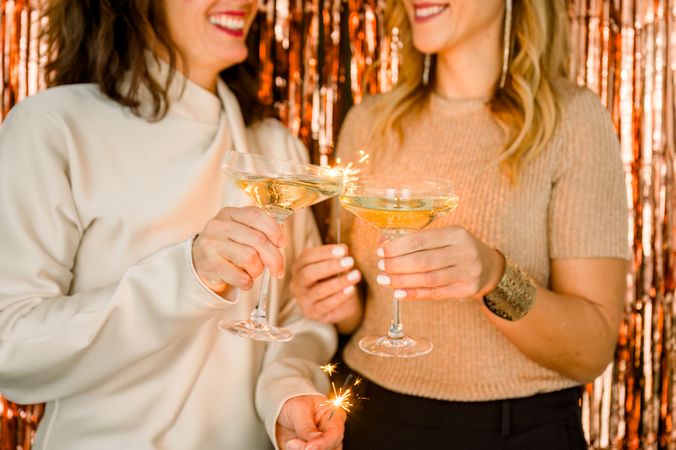 Crop women proposing toast during party