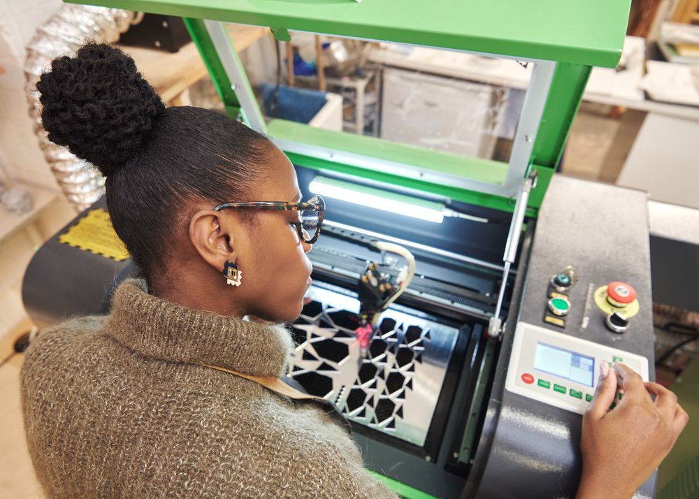 Black designer working with laser cutter
