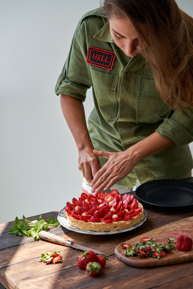 Female cook cutting strawberry cake