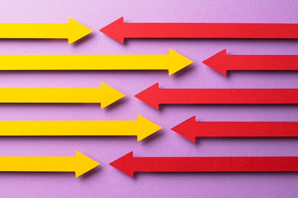 Yellow and pink paper arrows facing each other