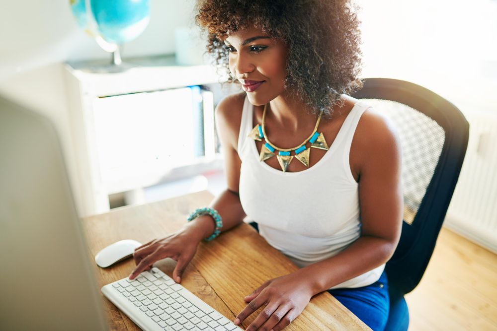 Black woman typing in her home office