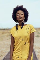 Portrait of young woman in yellow dress standing in desert