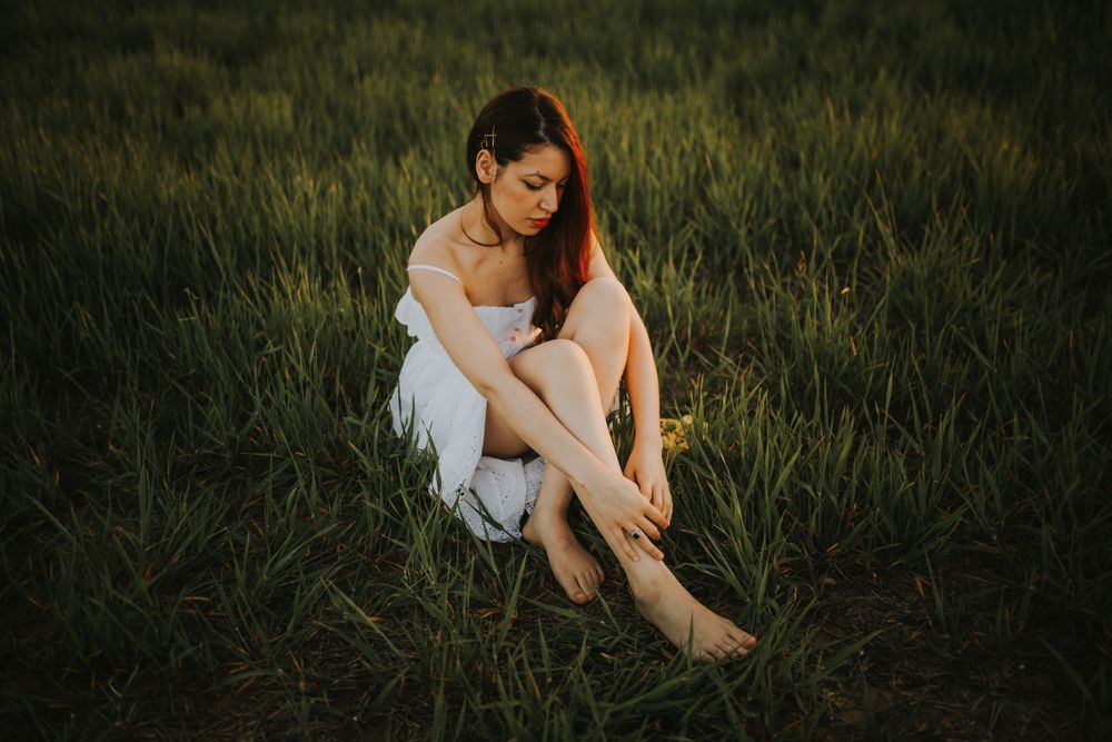 Barefoot woman with flowers in meadow