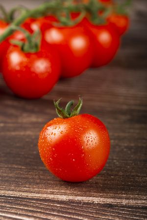 Ripe tomatoes on the wooden table.