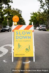 “Slow down” sign in the middle of city street 5zryo5