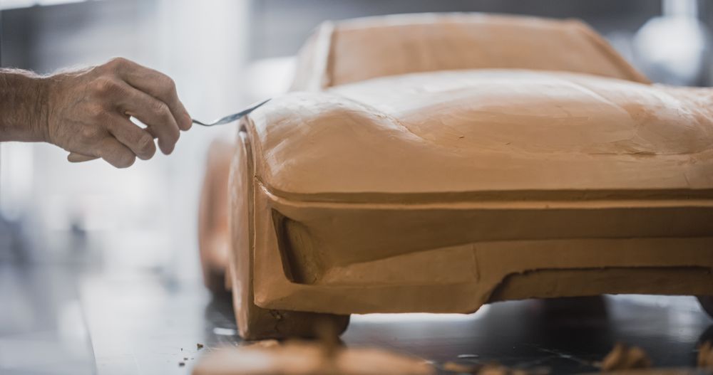 Close Up of a Specialist Modeler Working on Vehicle Production First Step, Creating a Miniature Scale 3D Car Model Out of Clay.