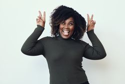 Black woman making a silly face with her tongue out and peace signs