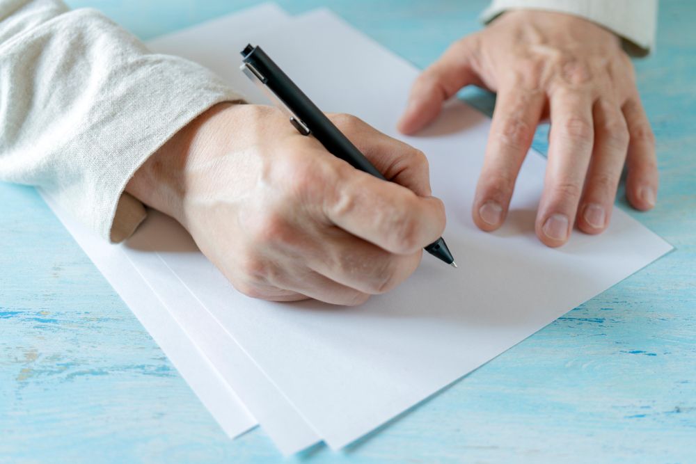 Person writing on blank paper
