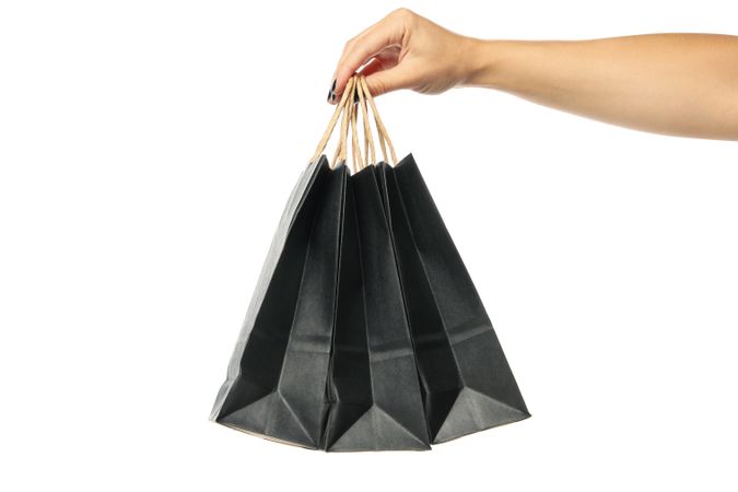 Female hand hold paper bags, isolated on light background