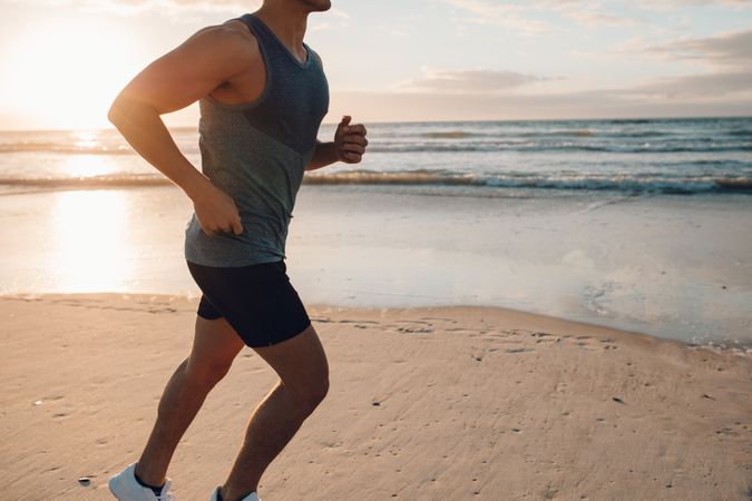Young man running along the beach in morning