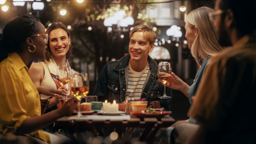 Diverse Group of Friends Enjoying Nightlife in a Street Cafe.