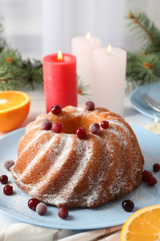 Cake with powder sugar and cranberry on table. Christmas concept
