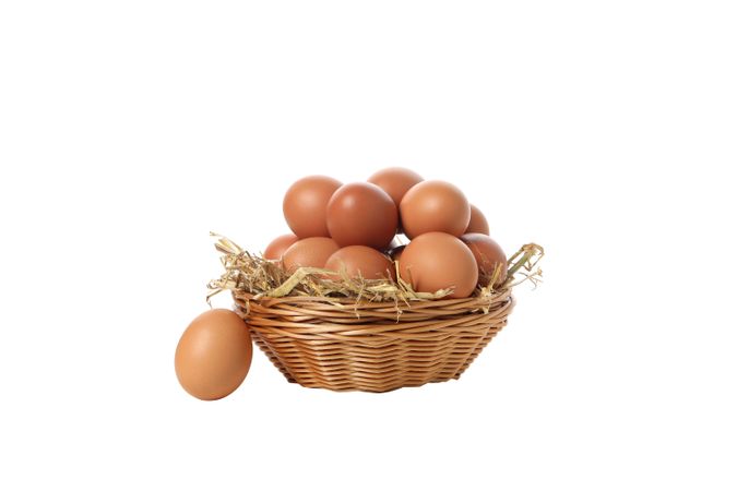 eggs in a round basket, isolated on blank background.