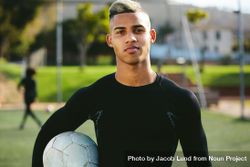 Athletic soccer player holding ball on a field 5kPVP4