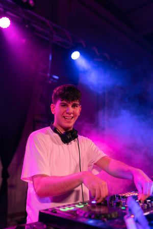 Portrait of a happy DJ smiling at camera while working