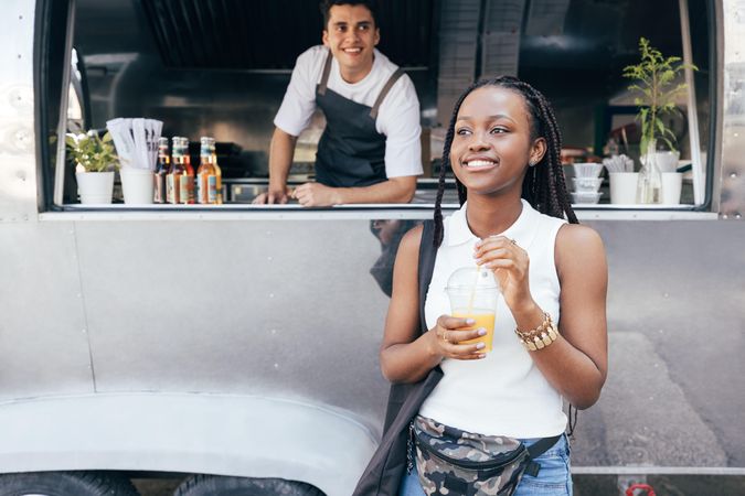 Woman walking away from food truck with fresh juice