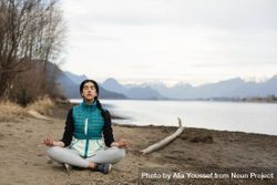 Young woman meditating on the lake shore 4mDjX5