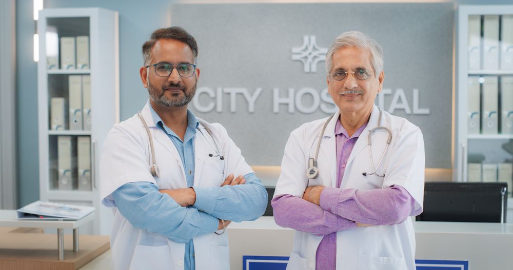 Portrait of Two Male Indian Doctors in a Hospital Smiling and Looking at the Camera. Medical Professionals