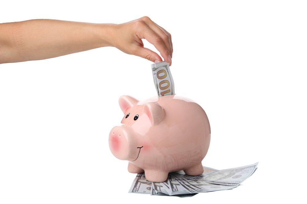 American cash in hand and piggy bank, isolated on light background