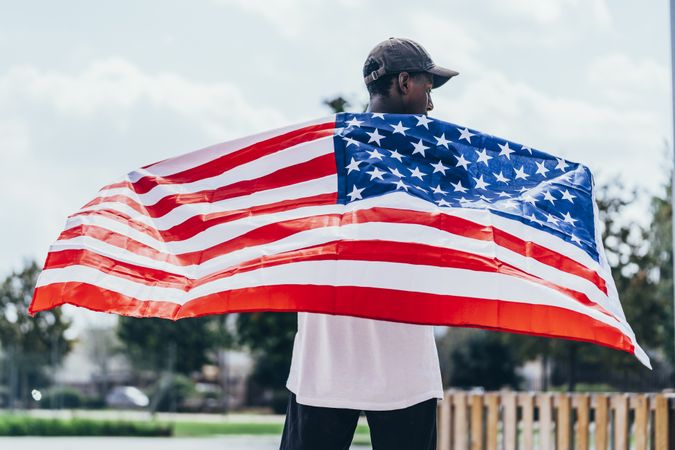 Black man wearing American Flag outside