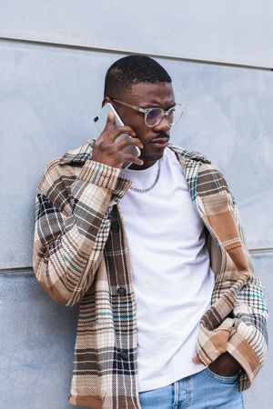 Stylish Black male using smartphone on street