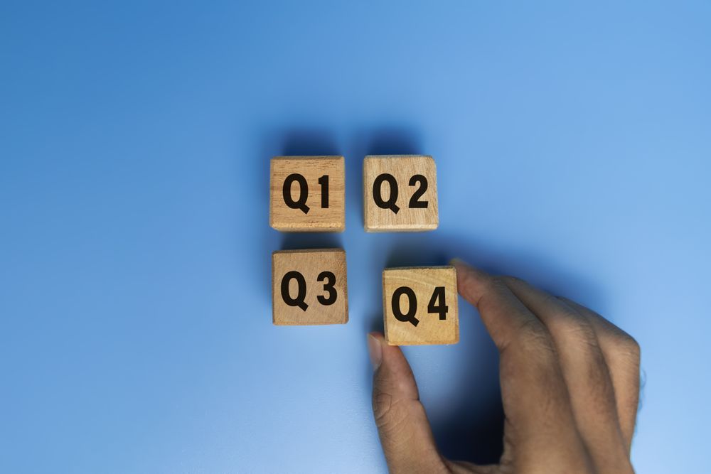 concept of quarterly report on wooden cubes isolated on blue background