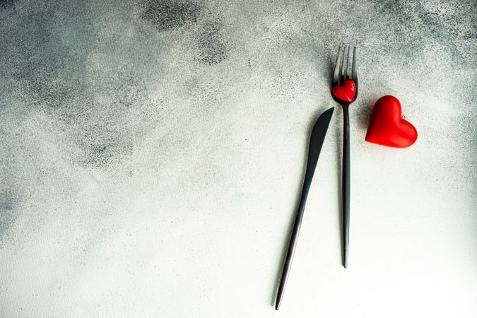 Cutlery on grey counter with red heart decorations