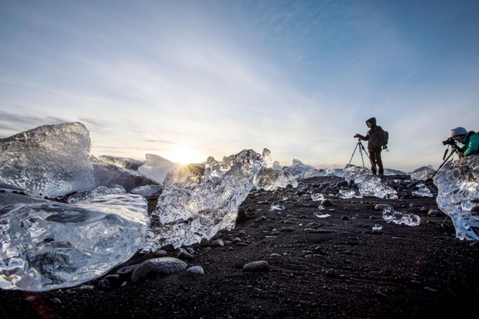 Two people taking photographs of glaciers