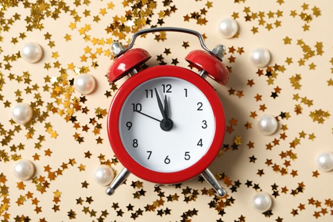 Alarm clock and glitter on blue background. Happy new year
