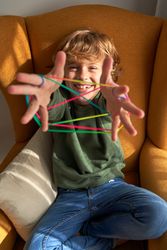 Happy kid enjoying string game at home