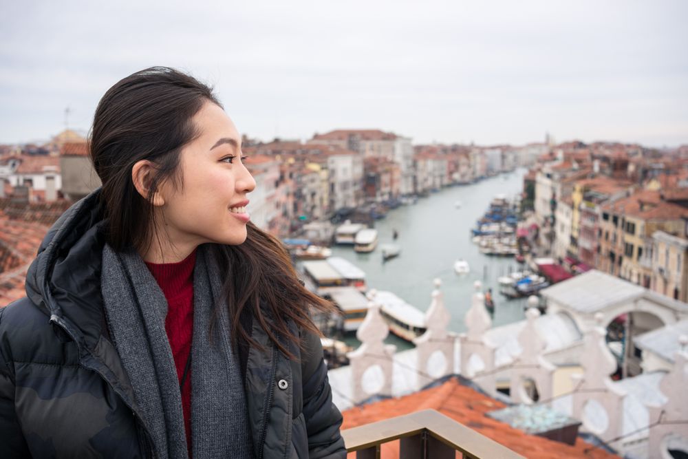 Content Asian female tourist at old city with waterlines