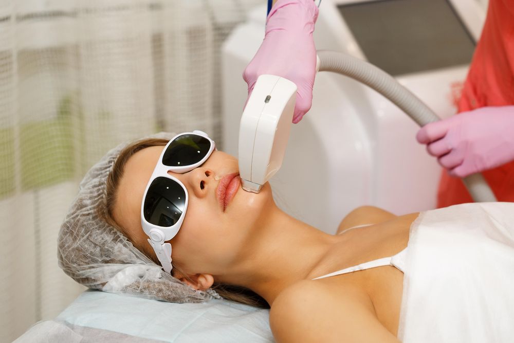 Female with laser hair tool working on chin