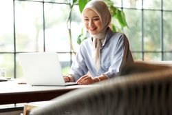 Young Asian Muslim Business Woman Wearing Hijab Working  with Laptop