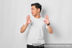 Asian male in grey studio gesturing “no” with both hands facing forward 5zD8Nb