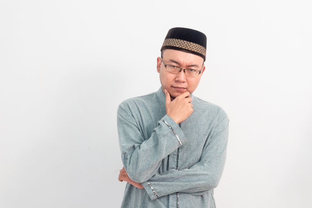 Thoughtful Muslim man doing thinking gesture in Ramadan