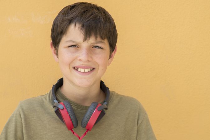 Smiling teen boy posing with red headphones